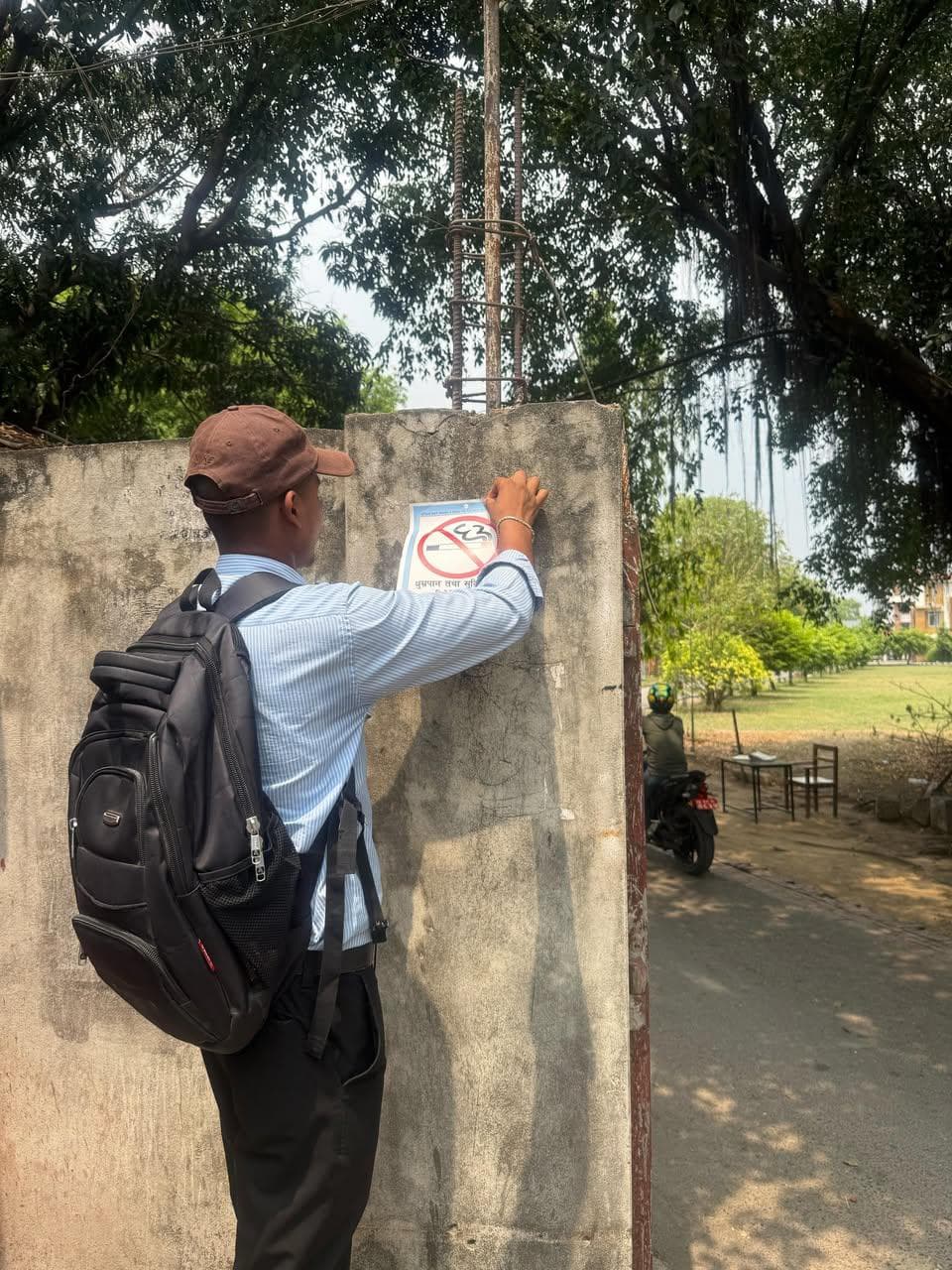 Tobacco Control Advocate installing Smoke-Free sticker at Universal College of Medical Sciences Teaching Hospital, Bhairahawa