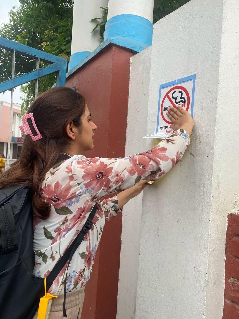 TAPAS advocate installing Smoke-Free sticker at a public space in Tilottama Municipality